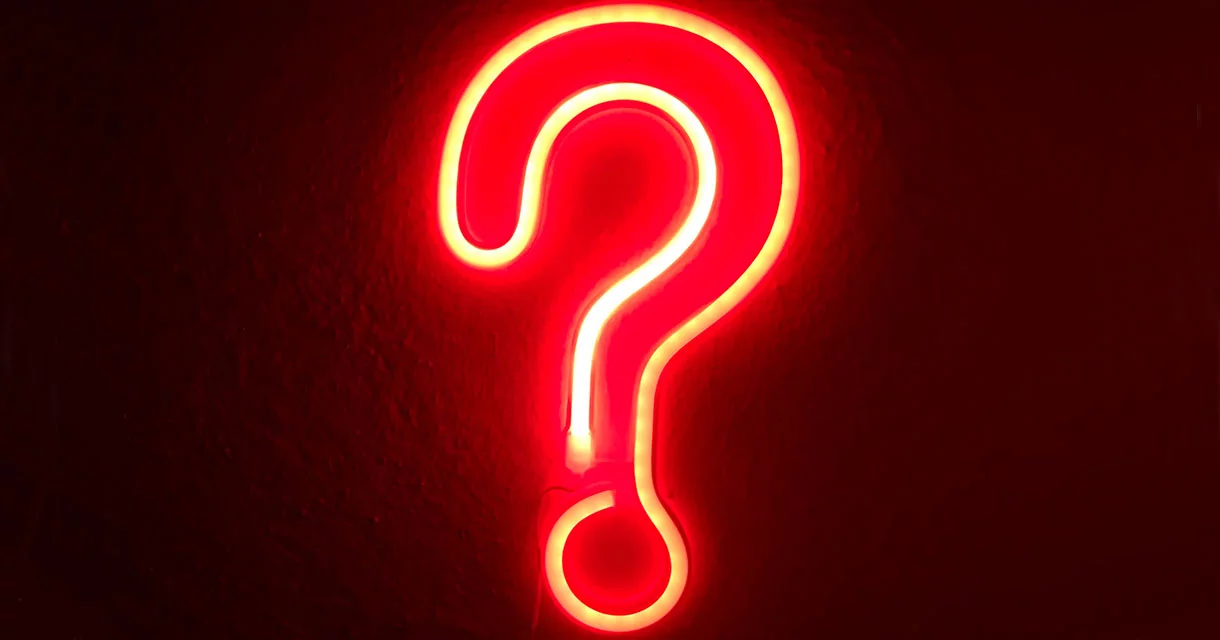 Neon question mark on a dark background